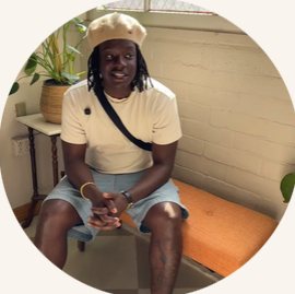 Raymell Williams II seated, wearing a cream beret